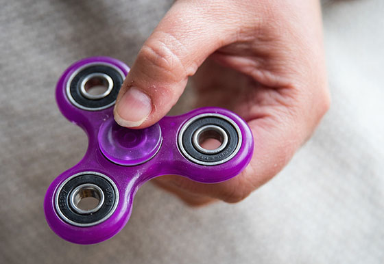 NEW YORK, NY - MAY 5: In this photo illustration, a woman holds a fidget spinner, May 5, 2017 in the Brooklyn borough of New York City. Fidget spinners have become the latest toy sensation and some schools have banned them because they've become a distraction. (Photo Illustration by Drew Angerer/Getty Images)